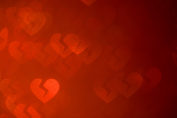 De-focused broken luminous hearts on red (left side). Abstract red background