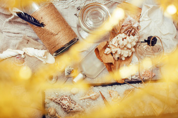 a lot of sea theme in mess like shells, candles, perfume, girl stuff on linen, pretty textured post card view vintage