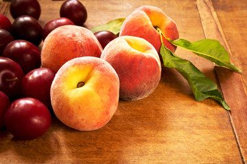 Naklejka na ściany i meble Fresh juicy peaches and plums on the kitchen table