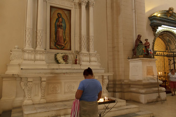 Fototapeta na wymiar Señora orando a la virgen de guadalupe en la catedral de la asuncion leon nicaragua