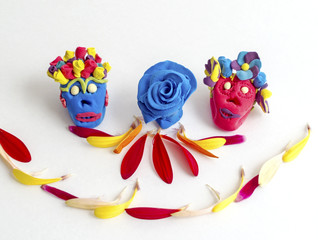 Clay day of the dead sugar skulls with flower petals.
