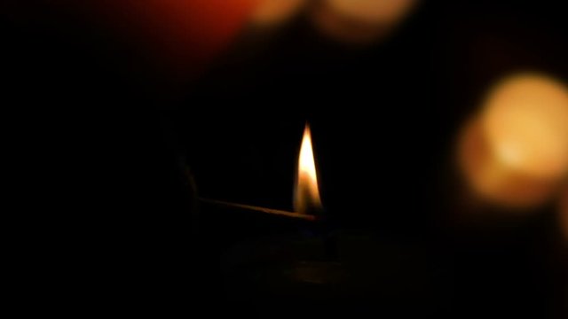 Kerze anz&uuml;nden - adventskerze auf dunklem Hintergrund mit Unsch&auml;rfe in Zeitlupe
