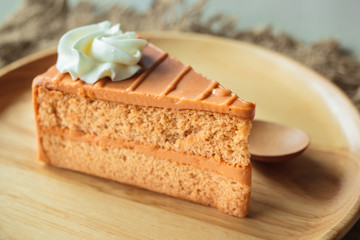 Thai tea layer cake on wood plate.