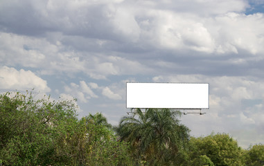 Billboard white blank with room to add your own text. Rural scene on background with white cloud and blue sky for outdoor advertising, banners with clipping path on a street