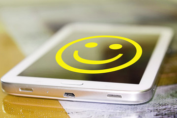 The smiley face on the phone screen . The concept of good mood .