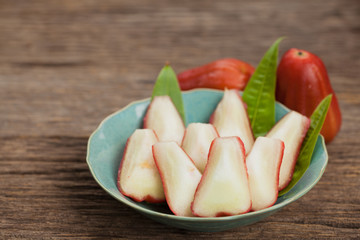 whole and half cut fresh rose apple fruit on wooden,natural back