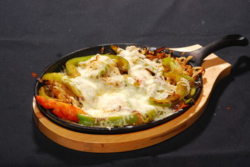 Sizling mexican sausage and cheese on skillet