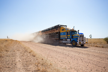 Double deck cattle road train approaching on dusty outback road