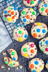 Shortbread cookies with multi-colored candy and chocolate chips on cooling rack, vertical, top view