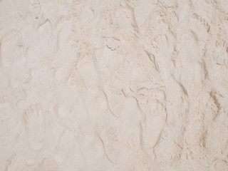 Many foot prints in sand on the beach.