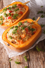Baked pumpkin stuffed with couscous, meat and cheese close-up. Vertical