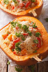 Baked pumpkin stuffed with couscous, meat and vegetables close-up. vertical