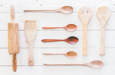 Wooden kitchen utensils on white  wooden background