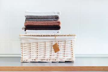 Pile color pure towels lies wattled basket table