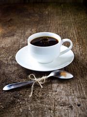 cup of coffee on the wooden table with falling drop