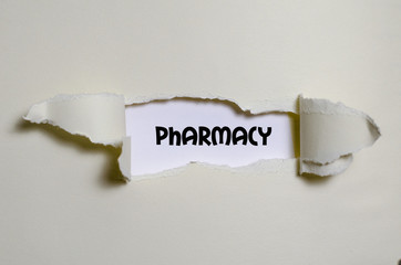 The word pharmacy appearing behind torn paper