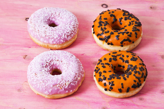 collection of colorful donuts on wooden pink
