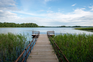 Obraz premium Diminishing perspective of wooden suspension footbridge over riv