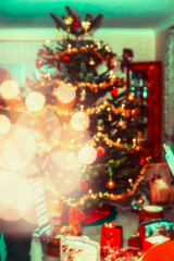 Blurred Christmas home scene with decorated Christmas  tree, gifts and festive bokeh lighting