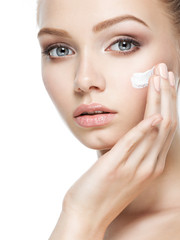 Beauty face of woman with cosmetic cream on face