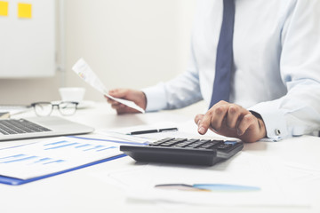Man using calculator and holding document