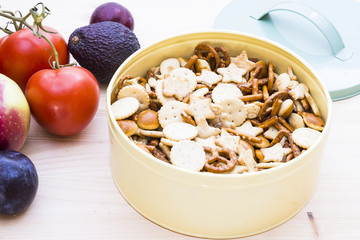 Autumn mood with apples, plums, tomatoes, avocados and a metal bowl with crackers