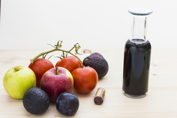 Autumn mood with apples, plums, tomatoes, avocados and a bottle of red wine