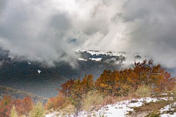 The slope with snow and beautiful, colorful autumn trees