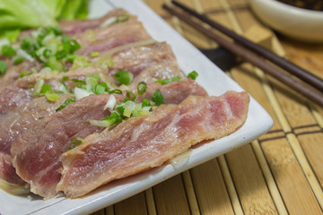 Place the sliced beef on white plate with salad place