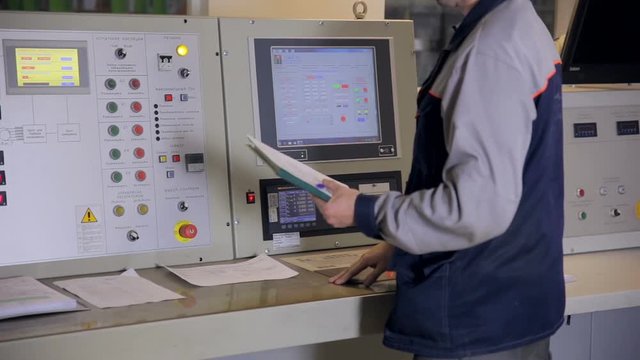 Engineer operating industrial control panel with display, buttons, swithes. Slider shoot. Nuclear plant, thermal power plant control room. HD.