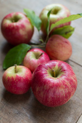 Apples on a wooden backgroound, one with leaves