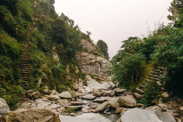 Fototapeta na wymiar Misty mountain with creek and rocks in Bhagsu, Dharamsala, India