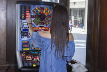 woman playing slot machine in London pub