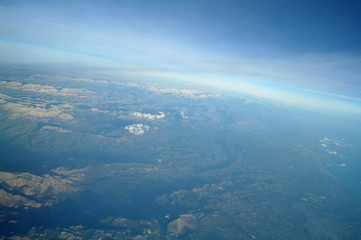 Aerial view above clouds and landscape