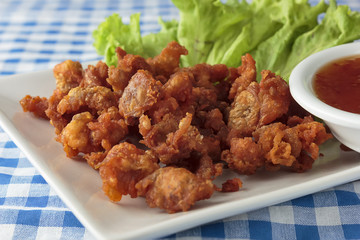 Fried chicken skin on blue and white tablecloth