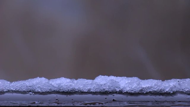 Heavy snow falling on the outer rim where some snow flakes are melting when they touch surface