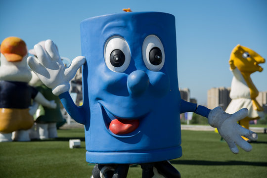 Close up shot of blue mascot character waving at camera