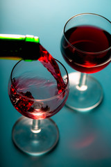 Pouring wine into the glasses, blue background