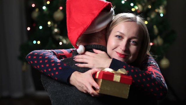 Young couple hugging with wrapped xmas present