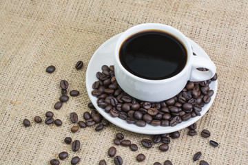 White cup with coffee drink on jute bag background