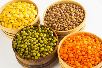 Four varieties of lentils in wooden bowls.