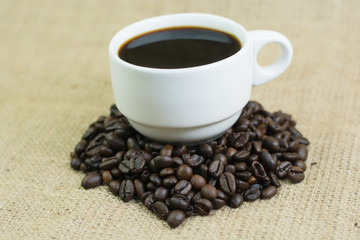 White cup with coffee drink on jute bag background