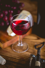 Glass of wine on wooden table, atmospheric composition
