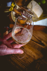 Man is pouring white wine into the glasses