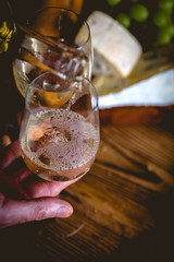 Man is pouring white wine into the glasses