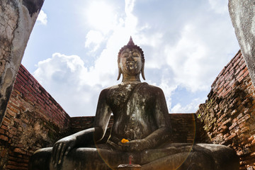 Attitude of subduing Mara buddha with lens flare light blue sky