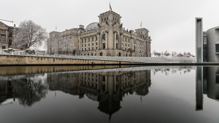 Berlin, Germany Winter The Reichstag is reflected in the cold waters of the Spree.