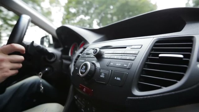 Hands of a man driving a car in slow motion