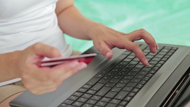Close up shot of woman s hands. Young woman buying goods from the internet and entering number security code from credit card on laptop. Online, technology and internet concept.
