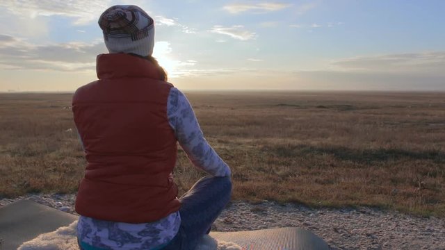 Beautiful girl meditates in savannah